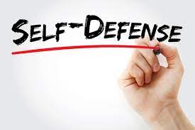 picture of a hand holding a pen next to the words self defense underlined in red