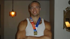 picture of bestpersonaldevelopmentcourses.com transformation coach sean smiling and wearing hos gold medal after winning the gold in beraska state games beach wrestling